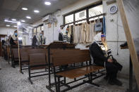 Ultra-Orthodox Jews wearing face masks during a morning prayer in a synagogue separated by plastic partitions, follow new government measures to help stop the spread of the coronavirus, in Bnei Brak, Israel, Friday, Sept 18, 2020. Israel is set to go back into a three-week lockdown later Friday to try to contain a coronavirus outbreak that has steadily worsened for months as its government has been plagued by indecision and infighting. The closures coincide with the Jewish High Holidays, when people typically visit their families and gather for large prayer services. (AP Photo/Oded Balilty)