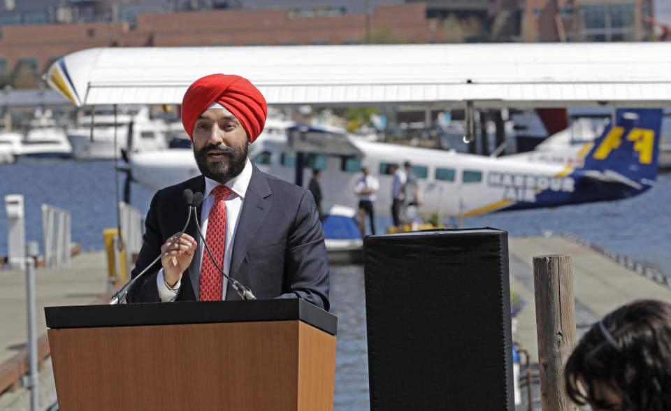 Navdeep Bains, Canada's Minister of Innovation, Science and Economic Development, speaks Wednesday, April 25, 2018, on Lake Union in Seattle at a news conference announcing that a partnership between Harbour Air and Kenmore Air will start offering direct one-hour seaplane flights between downtown Seattle and Vancouver, British Columbia, beginning Thursday. Officials said Microsoft President Brad Smith was a key proponent of bridging the 120-mile gap between the two cities, which is commonly referred to as the Cascadia Innovation Corridor. (AP Photo/Ted S. Warren)