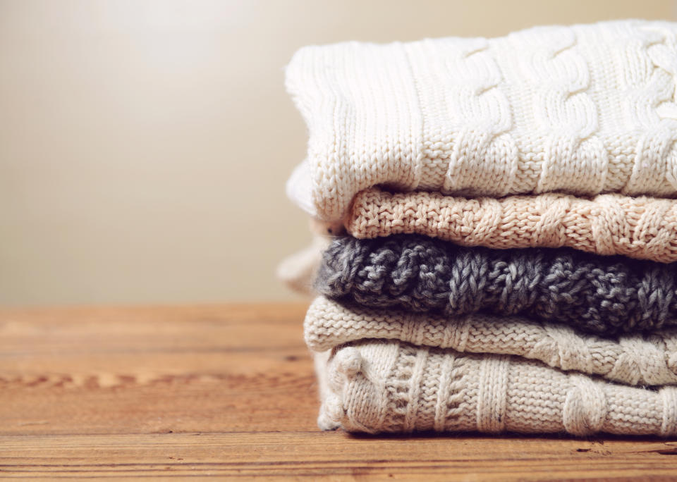 stack of sweaters on a wooden table