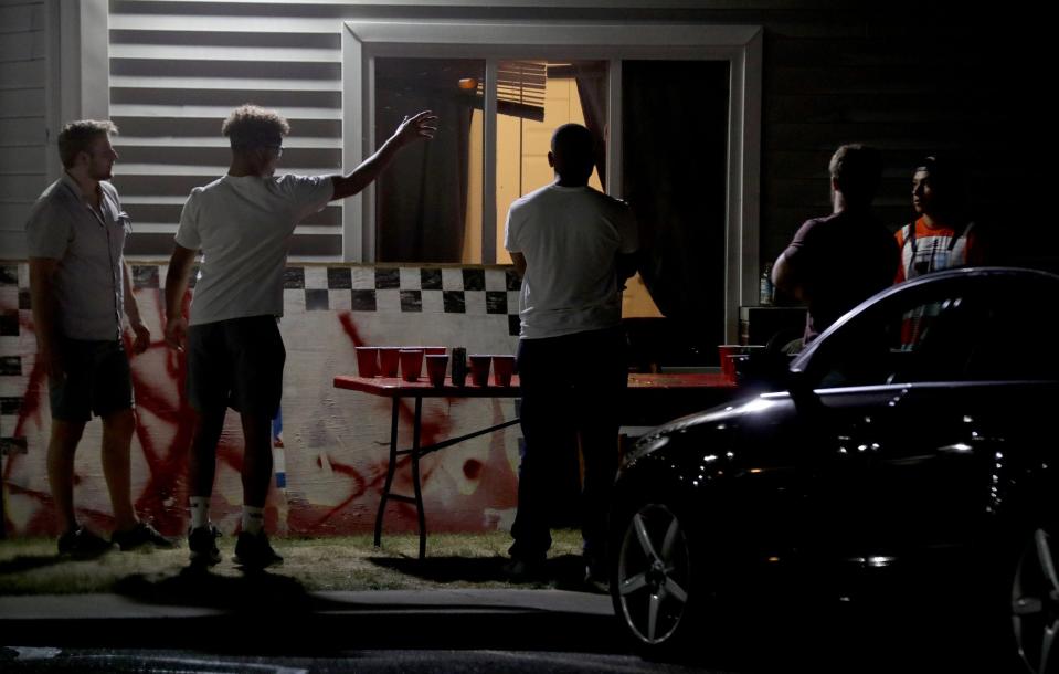College students play beer pong.