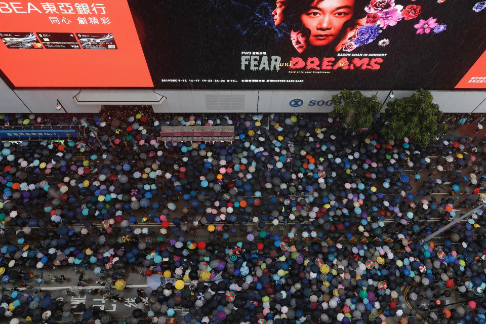 In this Sunday, Aug. 18, 2019, file photo, demonstrators carry umbrellas as they march along a street in Hong Kong. Heavy rain fell on tens of thousands of umbrella-ready protesters as they started marching from a packed park in central Hong Kong, where mass pro-democracy demonstrations have become a regular weekend activity. (AP Photo/Vincent Yu, File)