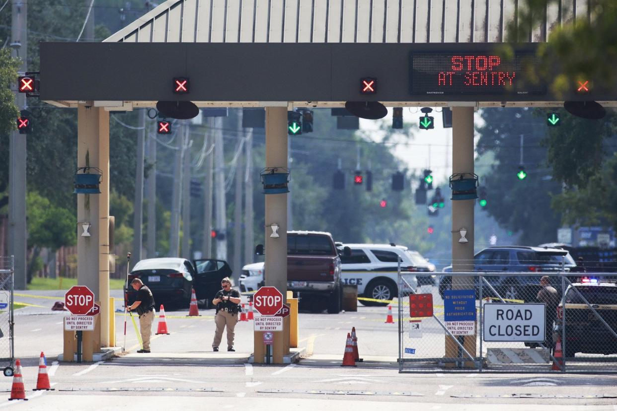 Officials work the scene of a crash that left the driver dead Thursday morning after trying to get past Naval Air Station Jacksonville's Birmingham Gate and slamming into the activated security barrier. The Florida Highway Patrol said the man was fleeing a hit-and-run.
