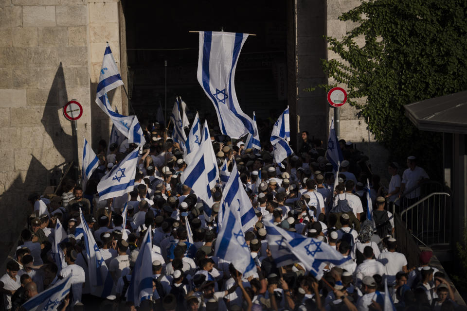 Israelis wave national flags during a march marking Jerusalem Day, an Israeli holiday celebrating the capture of east Jerusalem in the 1967 Mideast war, as they enter through the Damascus Gate in the Jerusalem's Old City, Wednesday, June 5, 2024. Thousands of mostly ultranationalist Israelis are taking part in an annual march through a dense Palestinian neighborhood of Jerusalem’s Old City. (AP Photo/Leo Correa)