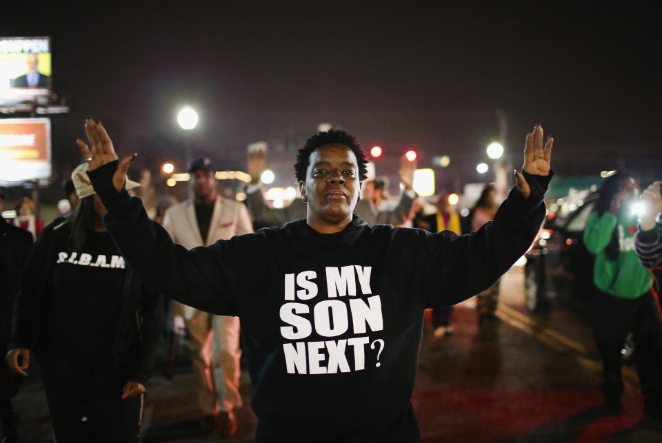 Demonstrators protest in front of the police station on March 12, 2015 in Ferguson, Missouri. Two police officers were shot yesterday while standing outside the station observing a similar protest. Ferguson has faced many violent protests since the August shooting death of Michael Brown by a Ferguson police officer. (Photo by Scott Olson/Getty Images)