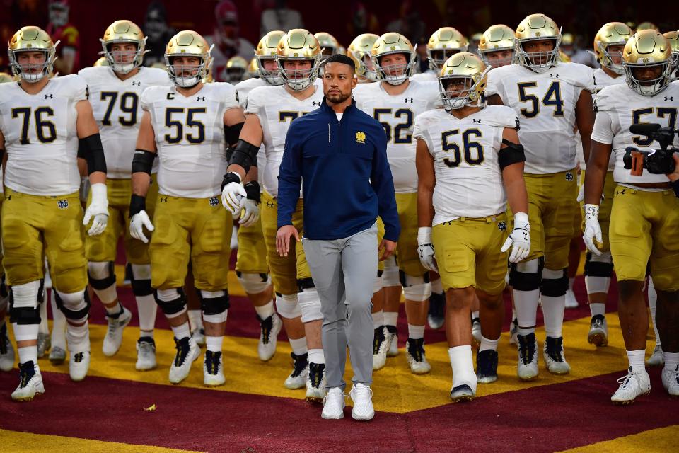 Notre Dame coach Marcus Freeman (center) led the Irish to victories in eight of their last 10 games, after an 0-3 start to his career that began in last year's Fiesta Bowl.