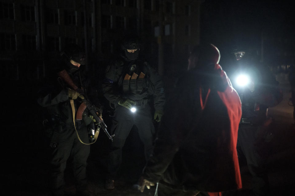 Ukrainian special police officers question a man as they patrol during a night curfew in Kharkiv, Ukraine, Sunday, March 27, 2022. (AP Photo/Felipe Dana)