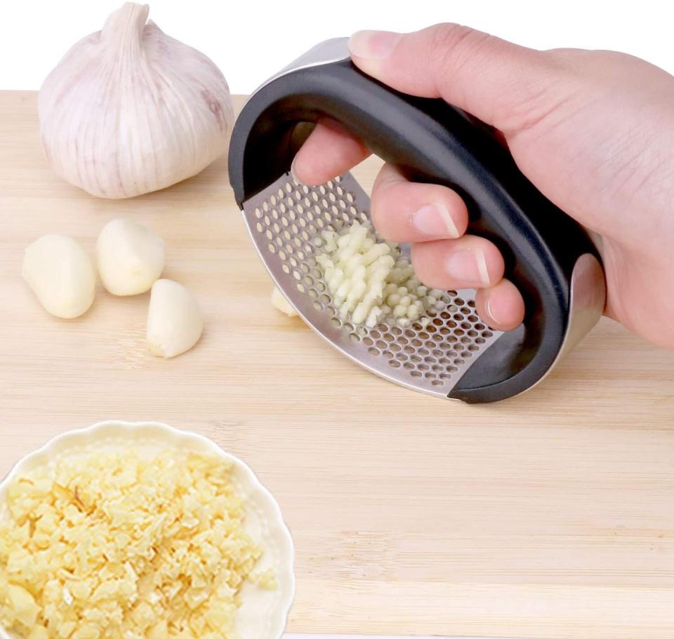 You'll be ready to rock 'n' roll with this &mdash; just don't invite any vampires over for dinner.<br /><br /><strong>Promising review:</strong> "Very sturdy and well-designed garlic press. The handle is solid and the metal used isn't cheap and presses well. The enclosed small knife scraper and garlic roller are very useful. <strong>It was extremely easy to clean three cloves and then press for fresh garlic instead of the old jarred stuff from a box store.</strong> Nothing is better than using it fresh for your marinades or cooking." &mdash; <a href="https://amzn.to/2PhhCew" target="_blank" rel="noopener noreferrer">Leips63<br /></a><br /><strong>Get it from Amazon for <a href="https://amzn.to/2QMy0nC" target="_blank" rel="noopener noreferrer">$14.99</a> (available in two colors).</strong>