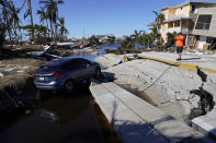 A man takes pictures of the destruction around the bridge leading to Pine Island, in the aftermath of Hurricane Ian in Matlacha, Fla., Sunday, Oct. 2, 2022. The only bridge to the island is heavily damaged so it can only be reached by boat or air. (AP Photo/Gerald Herbert)