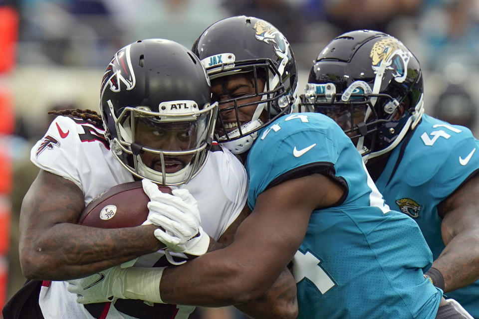Atlanta Falcons running back Cordarrelle Patterson, left, is stopped on a run by Jacksonville Jaguars linebacker Myles Jack, center, and linebacker Josh Allen, right, during the first half of an NFL football game, Sunday, Nov. 28, 2021, in Jacksonville, Fla. (AP Photo/Chris O'Meara)