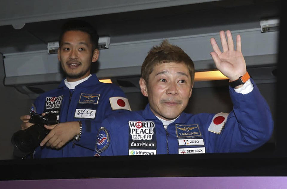 In this photo released by the Roscosmos Space Agency, spaceflight participants Yusaku Maezawa, right, and Yozo Hirano, left, of Japan, members of the main crew of the new Soyuz mission to the International Space Station (ISS) sit in a bus prior the launch at the Russian leased Baikonur cosmodrome, Kazakhstan, Wednesday, Dec. 8, 2021. (Pavel Kassin, Roscosmos Space Agency via AP)