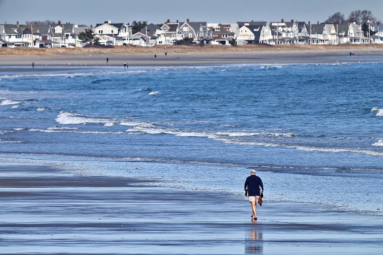 Warming weather allows folks to get to their feet in the sand at Nantasket Beach on Wednesday March 13, 2024