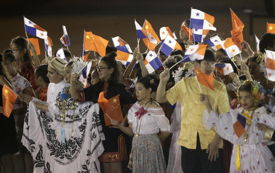 FILE - In this Dec. 2, 2018, file photo, children wave Panamanian and Chinese national flags during a welcome ceremony for China's President Xi Jinping and first lady Peng Liyuan at the Tocumen International Airport in Panama City. China’s expansion in Latin America of its Belt and Road initiative to build ports and other trade-related facilities is stirring anxiety in Washington. As American officials express alarm at Beijing’s ambitions in a U.S.-dominated region, China has launched a charm offensive, wooing Panamanian politicians, professionals, and journalists. (AP Photo/Arnulfo Franco, File)