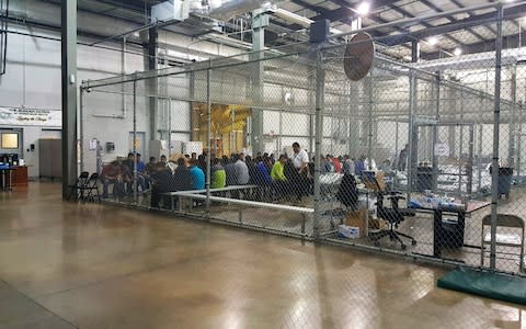 People who've been taken into custody related to cases of illegal entry into the United States, sit in one of the cages at a facility in McAllen, Texas - Credit: AP