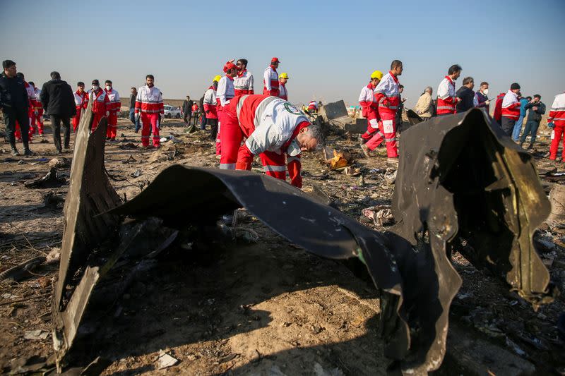 Red Crescent workers check the debris from the Ukraine International Airlines plane, that crashed after take-off from Iran's Imam Khomeini airport, on the outskirts of Tehran