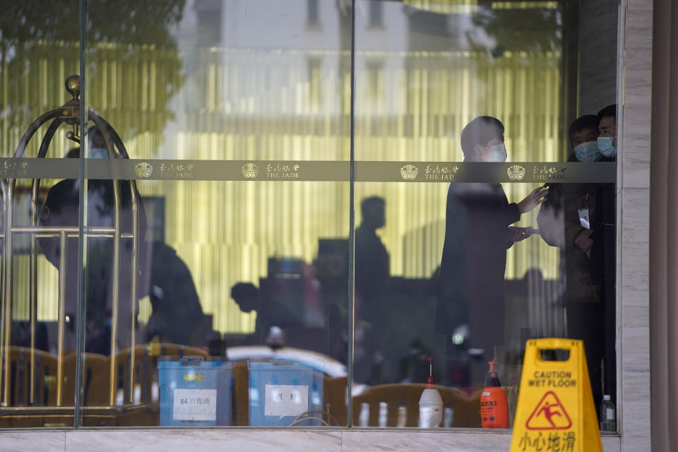 Workers are seen inside hotel where a team of experts from the World Health Organization are quarantined in Wuhan in centra China's Hubei province on Thursday, Jan. 28, 2021. A World Health Organization team has emerged from quarantine in the Chinese city of Wuhan to start field work in a fact-finding mission on the origins of the virus that caused the COVID-19 pandemic. (AP Photo/Ng Han Guan)