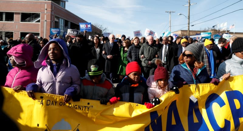 Seven of the democratic U.S. presidential candidates walk arm-in-arm with local African-American leaders during the Martin Luther King Jr. (MLK) Day Parade in Columbia