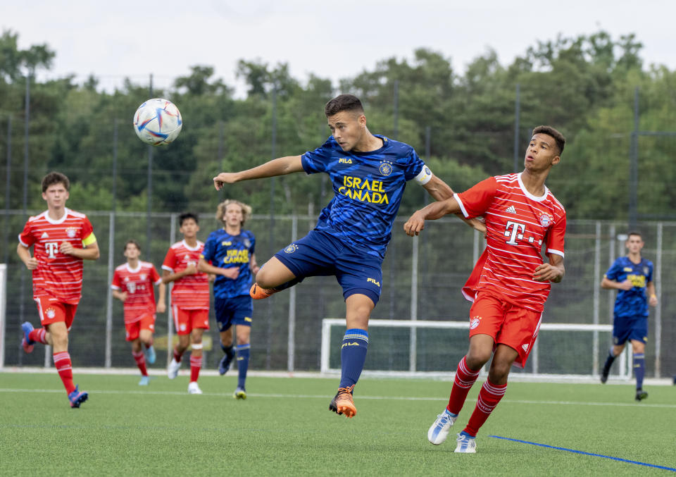 Youth players of Bayern Munich, red jersey, and Makkabi Tel Aviv challenge for the ball in Nuremberg, Germany, Friday, July 29, 2022. Some of Europe's best young soccer players from the under-17 teams of Chelsea, Bayern Munich, Bologna and other international clubs contest the Walther Bensemann Memorial Tournament in Nuremberg, where they also learn the dangers of intolerance by meeting Holocaust survivors, attending workshops and taking part in excursions.(AP Photo/Michael Probst)