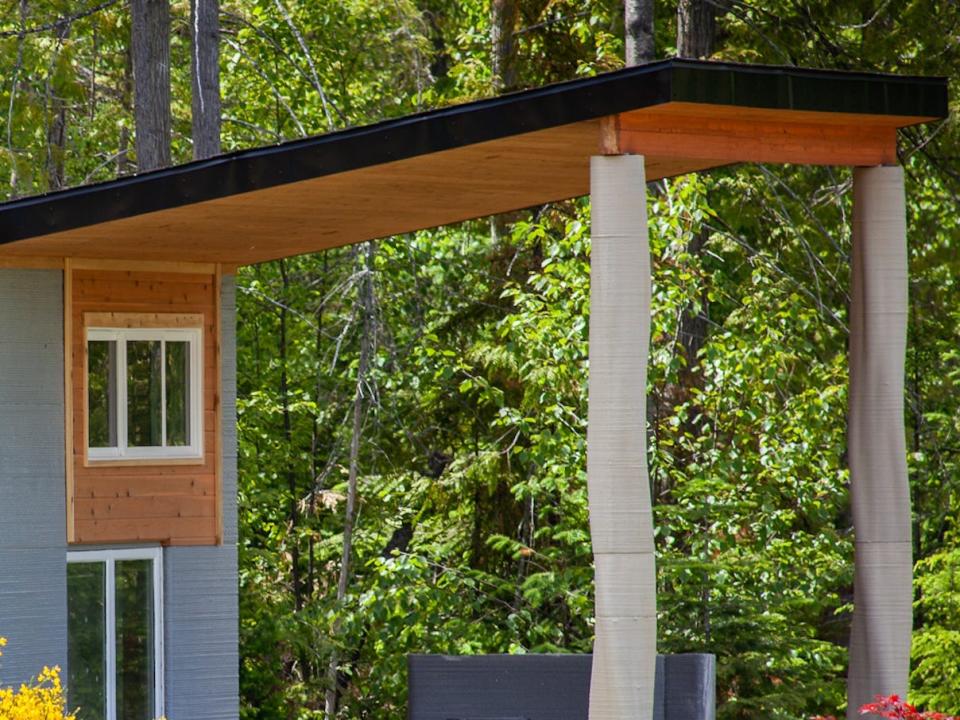 the exterior of the Fibonacci House among trees and grass