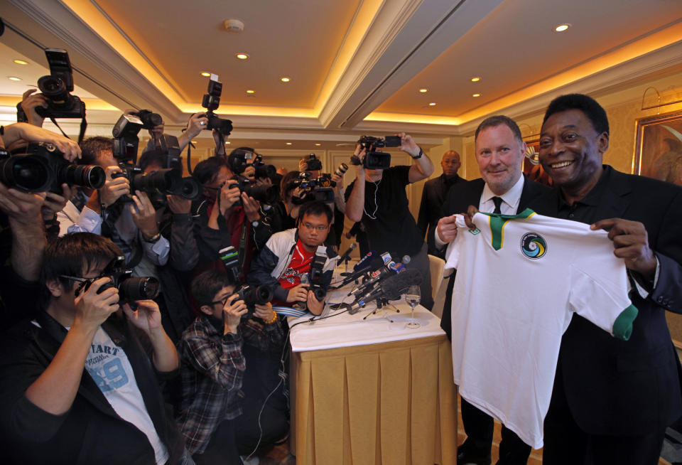 FILE - Brazilian soccer great Pele poses with Paul Kemsley, second right, chairman of the New York Cosmos, during a press conference in Hong Kong, March 7, 2011. Pele was in here to promote the rebirth of the Cosmos, hoping for the team to begin play in 2014. Pelé, the Brazilian king of soccer who won a record three World Cups and became one of the most commanding sports figures of the last century, died in Sao Paulo on Thursday, Dec. 29, 2022. He was 82. (AP Photo/Vincent Yu, File)