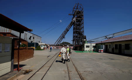 FILE PHOTO: Mine workers walk past the pit head at Sibanye Gold's Masimthembe shaft in Westonaria, South Africa, April 3, 2017. REUTERS/Mike Hutchings/File Photo