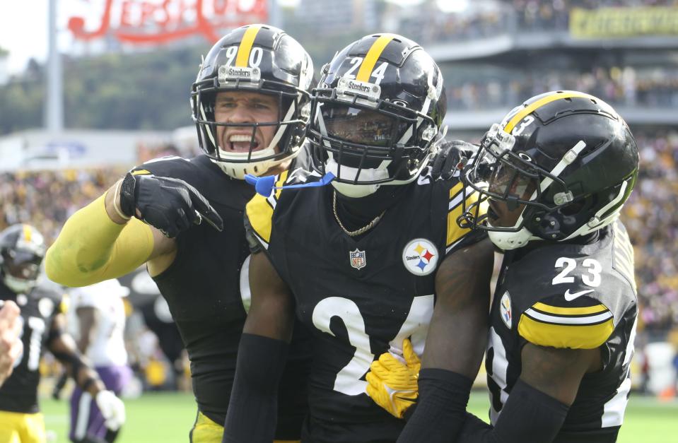 Steelers linebacker T.J. Watt (90) and safety Damontae Kazee (23) celebrate an interception by cornerback Joey Porter Jr. (24) in the end zone against the Ravens during the fourth quarter at Acrisure Stadium in Pittsburgh on Oct. 8, 2023.