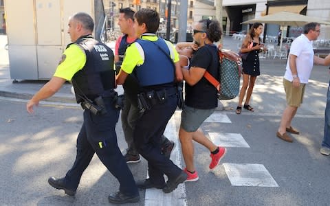 An injured person is carried in Barcelona, Spain - Credit:  Oriol Duran/AP