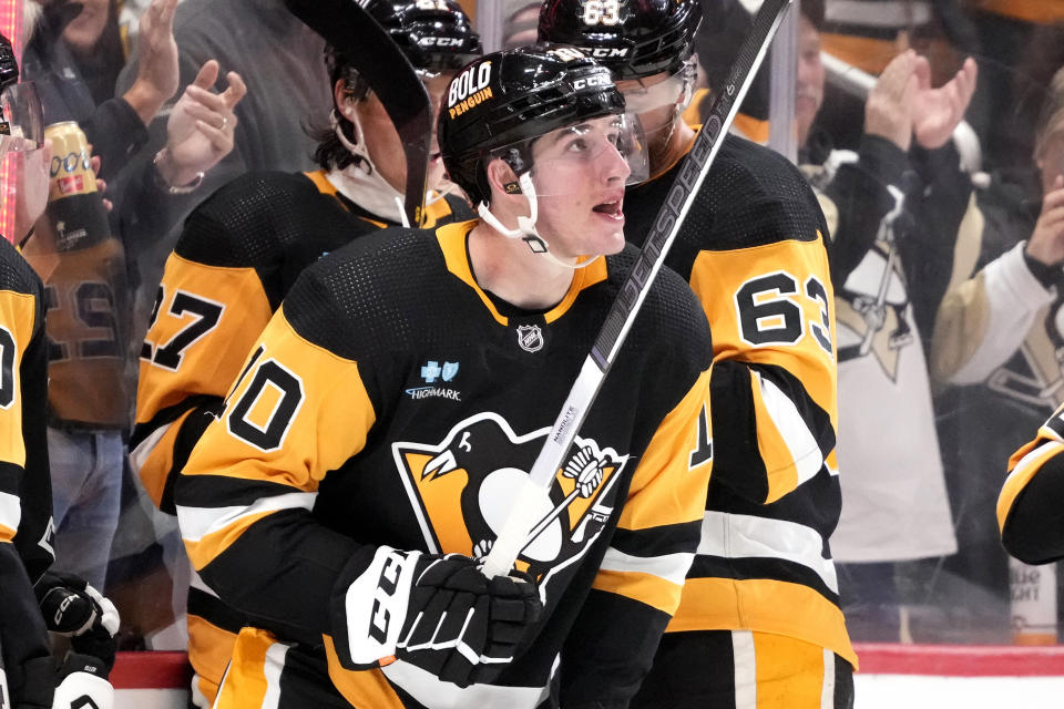 Pittsburgh Penguins' Drew O'Connor, front center, looks at the scoreboard as he heads to the bench after scoring during the second period of an NHL hockey game against the Buffalo Sabres in Pittsburgh, Saturday, Nov. 11, 2023. (AP Photo/Gene J. Puskar)