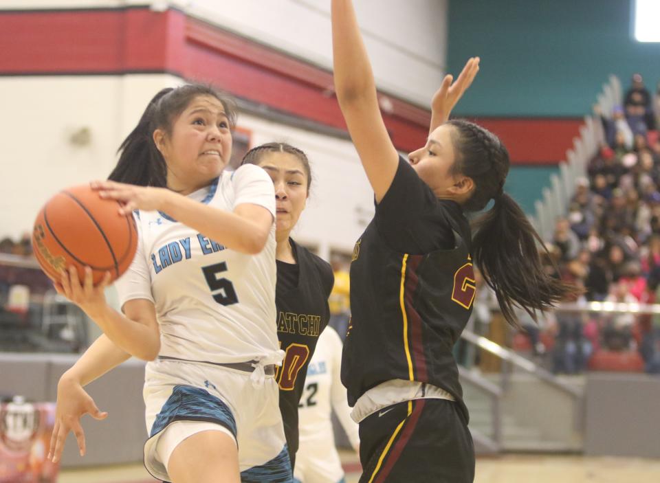 Navajo Prep's Tru Billie (5) goes into the lane and on her way to the basket against Tohatchi's Marisa Denetso (20) and Kiyanna Captain (40) during the fourth quarter of the District 1-3A championship game, Saturday, Feb. 25, 2023 at the Chieftain Pit at Shiprock High School.
