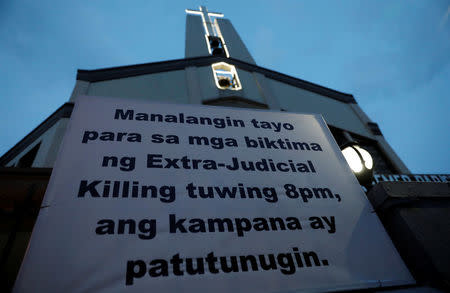 A sign is posted outside a Catholic church which translates to "Let us pray for the victims of extrajudicial killings, bells will toll at 8:00pm" in Quezon City, metro Manila, Philippines September 22, 2017. REUTERS/Dondi Tawatao