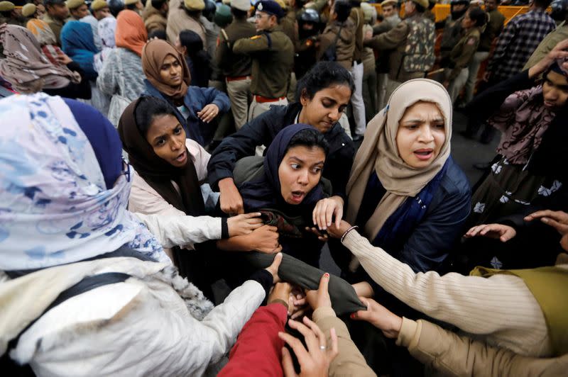 Police detain a protester outside Jamia Millia Islamia University during a protest against the Citizenship Amendment Bill in New Delhi