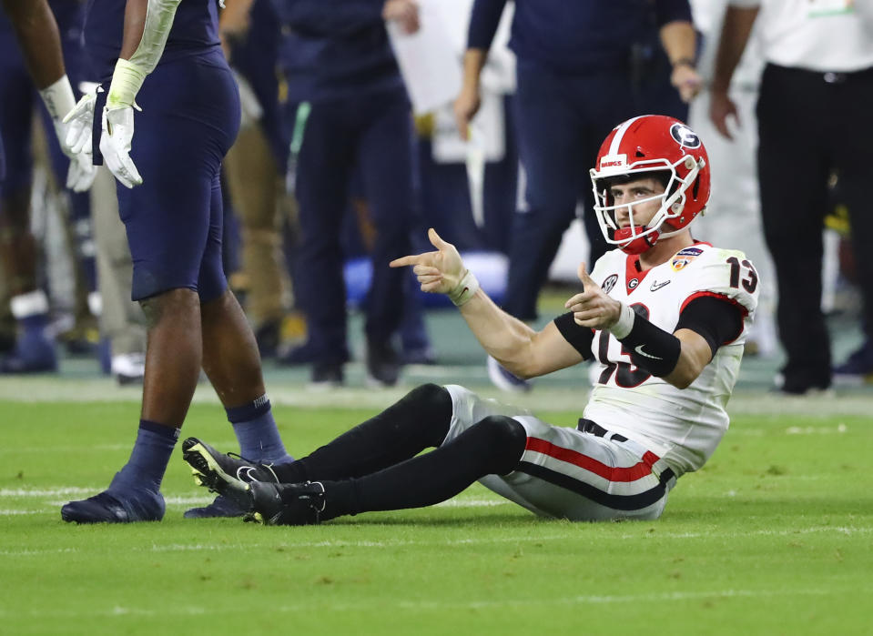Georgia Bulldogs quarterback Stetson Bennett (13) shoots his guns after a quarterback keeper in the 4th quarter of the 2021 College Football Playoff Semifinal between the Georgia Bulldogs and the Michigan Wolverines at the Orange Bowl at Hard Rock Stadium in Miami Gardens. (Curtis Compton/Atlanta Journal-Constitution via AP)