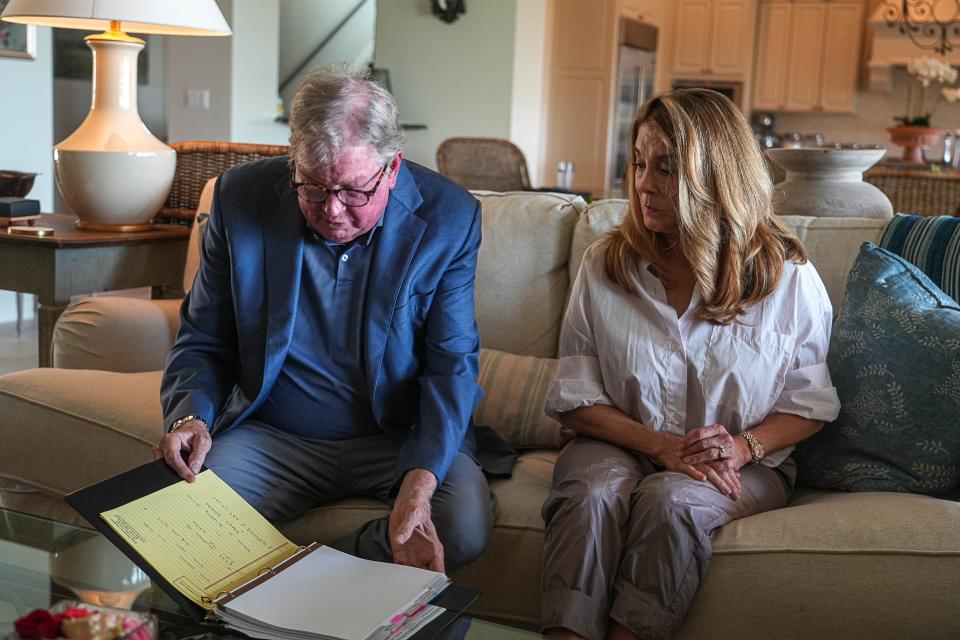 Jennifer Thompson watches her husband, Greg, look through documents in their home. In June, they learned that a forged deed, bearing forged signatures, claimed a new owner had bought their home on May 30.