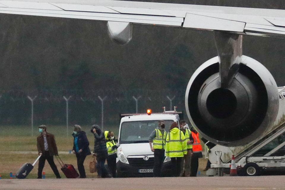 British nationals evacuated from Wuhan in China amid the novel coronavirus outbreak are helped by personnel (high visability jackets) as they disembark a chartered passenger jet at the Royal Air Force station RAF Brize Norton in Carterton, west of London, on January 31, 2020. - A charter plane carrying evacuees from the Chinese city at the centre of the deadly novel coronavirus outbreak arrived at Royal Air Force base Brize Norton in Britain on January 31. The flight touched down shortly after 1:30 pm (1330 GMT), with 83 British citizens and 27 others on board. (Photo by Adrian DENNIS / AFP) (Photo by ADRIAN DENNIS/AFP via Getty Images)
