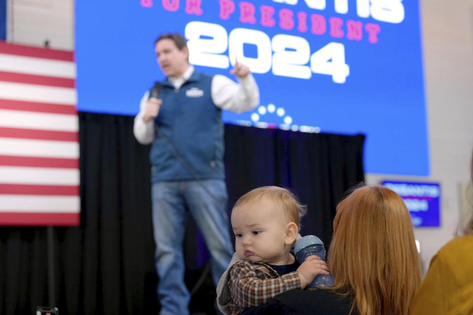 A baby is carried in the audience as Republican presidential candidate Florida Gov. Ron DeSantis speaks during a campaign event at The Hangout on Saturday, Jan. 20, 2024, in Myrtle Beach, S.C. (AP Photo/Meg Kinnard)