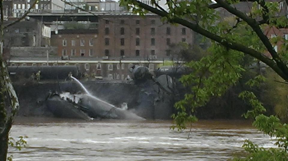 Emergency personnel attend to a CSX Corp train carrying crude oil that derailed and burst into flames in downtown Lynchburg, Virginia, April 30, 2014. The derailment caused oil to spill into the James River and forced the evacuation of hundreds. (REUTERS/WSET/Handout via Reuters)