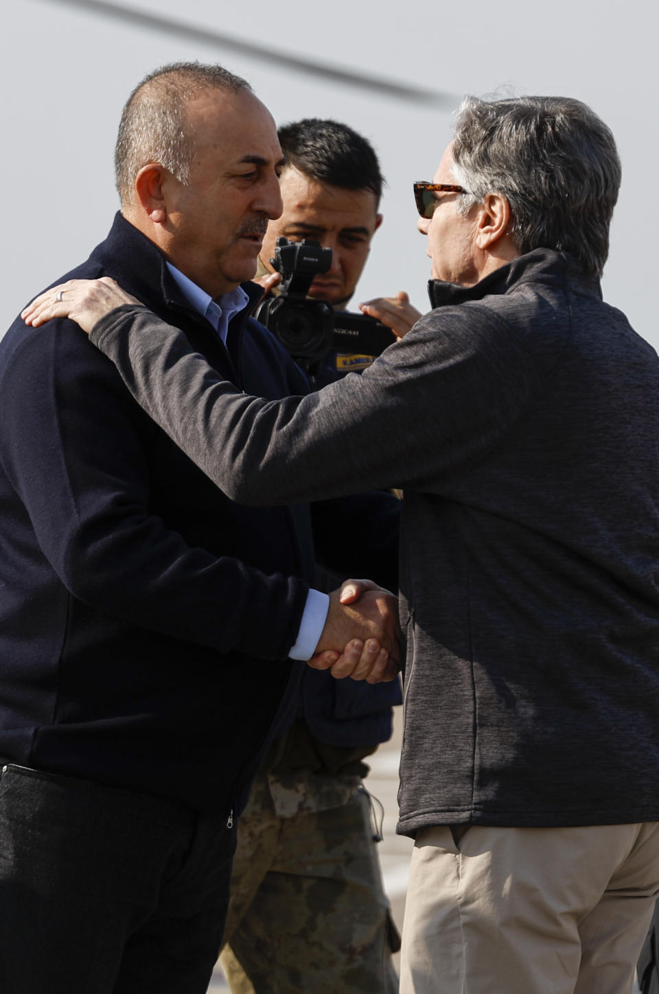 U.S. Secretary of State Antony Blinken, right, is greeted by Turkish Foreign Minister Mevlut Cavusoglu, at Incirlik Air Base near Adana, Turkey, Sunday, Feb. 19, 2023. (Clodagh Kilcoyne/Pool Photo via AP)