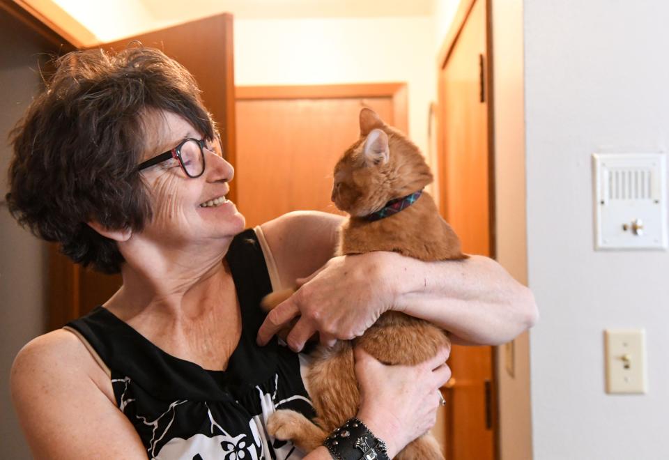 Penny hugs her cat on Thursday, April 14, 2022, at her home in Sioux Falls.