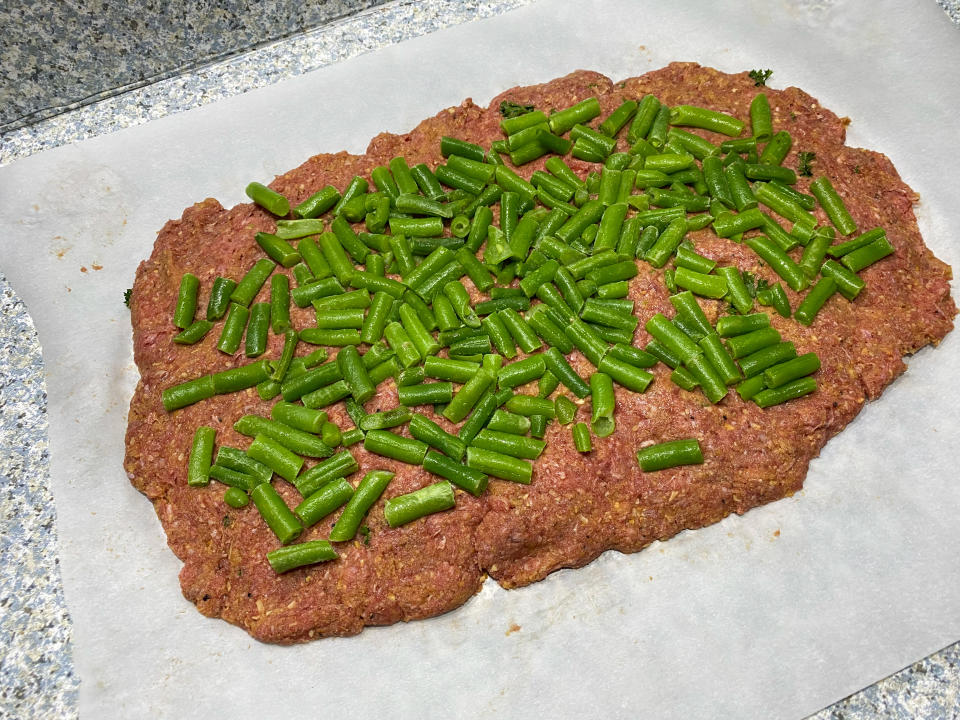 Before this meatloaf gets formed into a loaf, green beans get rolled into the center. (Terri Peters)