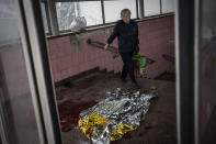 A woman walks past broken glass and blood after shelling in Kharkiv, eastern Ukraine, Thursday, May 26, 2022. (AP Photo/Bernat Armangue)