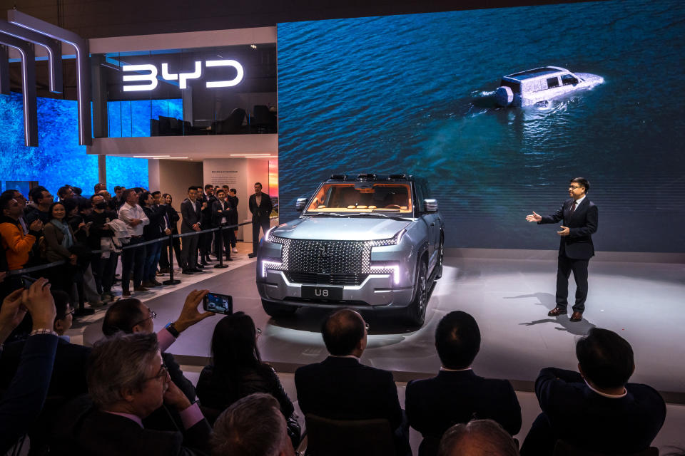 BYD Europe managing director Michael Shu (R) presents the BYD's Yangwang U8 giant SUV on February 26, 2024 during a press day of the Geneva International Motor Show in Geneva. (Photo by Fabrice COFFRINI / AFP) (Photo by FABRICE COFFRINI/AFP via Getty Images)
