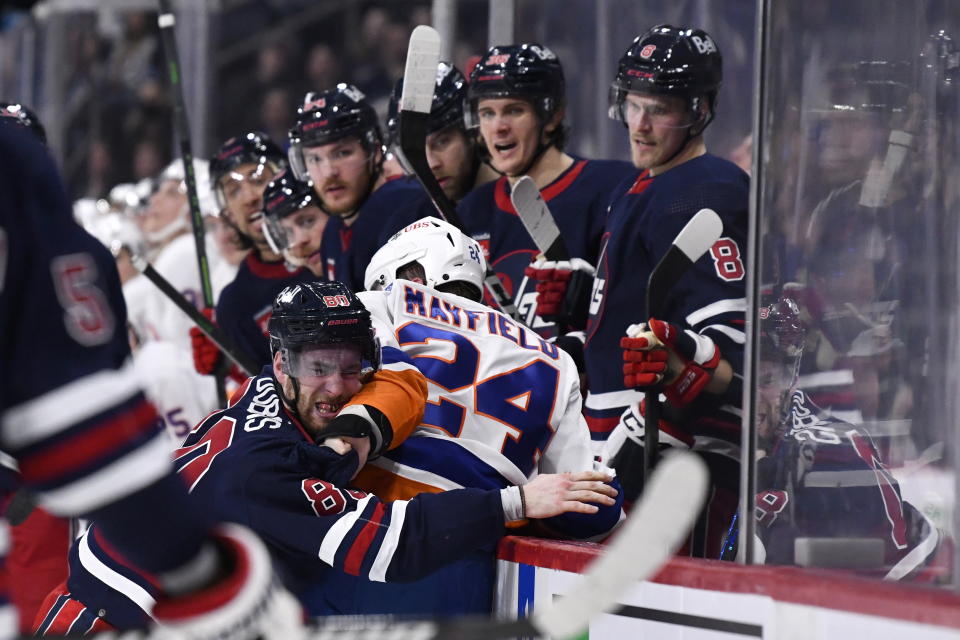 Winnipeg Jets' Pierre-Luc Dubois (80) fights with New York Islanders' Scott Mayfield (24) during second-period NHL hockey game action in Winnipeg, Manitoba, Sunday, Feb. 26, 2023. (Fred Greenslade/The Canadian Press via AP)