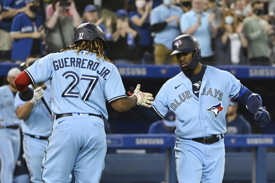 Toronto Blue Jays' Teoscar Hernandez, right, celebrates with Vladimir Guerrero Jr. (27) after hitting a two-run home run against the Oakland Athletics during the fourth inning of a baseball game Friday, Sept. 3, 2021, in Toronto. (Jon Blacker/The Canadian Press via AP