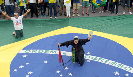 A man wears priest clothing and a mask of federal judge Sergio Moro as he takes part in a protest against corruption at the Liberdade square in Belo Horizonte, Brazil December 4, 2016. REUTERS/Washington Alves