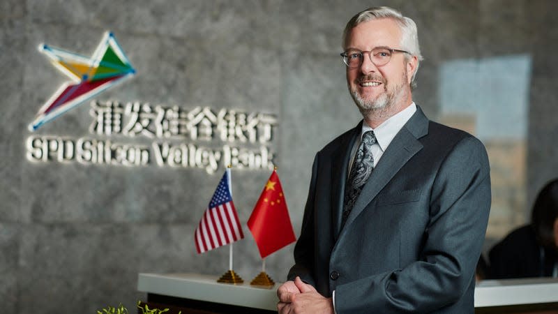 Former SVB executive Dave Jones at Silicon Valley Bank's joint venture in China, with US and Chinese flags on the counter behind him