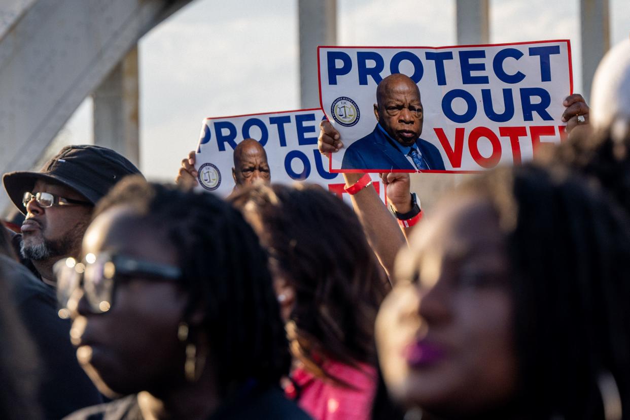 People march across the Edmund Pettus Bridge with placards bearing the image of the late U.S. Rep. John Lewis, for whom the most recent voting rights bill is named, during commemorations for the 57th anniversary of "Bloody Sunday" on March 06, 2022 in Selma, Alabama. 