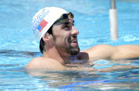 Michael Phelps talks with his coaches during practice, Wednesday, April 23, 2014, in Mesa, Ariz. The 22-time Olympic medalist is entered in three events at the Arena Grand Prix starting Thursday. (AP Photo/Matt York)