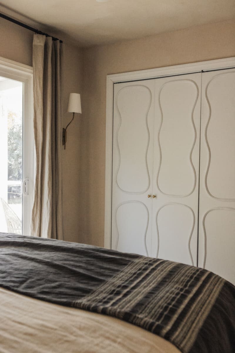 Bedroom closet with white doors with wavy relief pattern