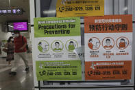 People wearing face masks pass by posters about precautions against new coronavirus at a subway station in Seoul, South Korea, Wednesday, July 8, 2020. (AP Photo/Ahn Young-joon)