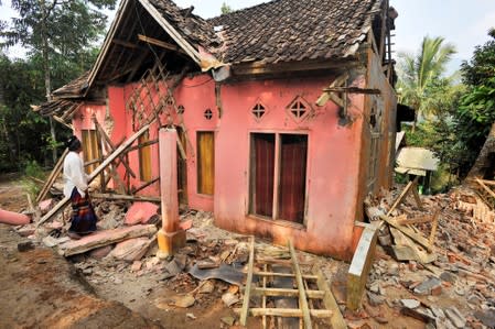 A man examines his house damaged after an earthquake hit in Pandeglang
