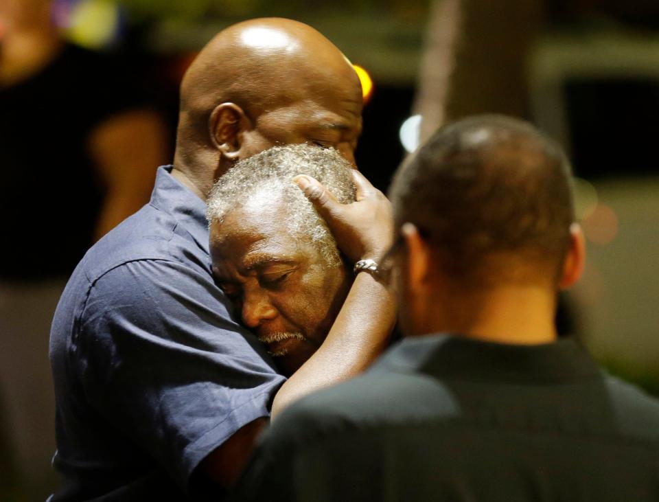 Worshippers embrace after a group prayer across the street from the scene of a shooting at Emanuel African Methodist Episcopal Church on June 17, 2015, in Charleston, S.C. A white man opened fire during a prayer meeting inside the historic Black church, killing multiple people, including the pastor, in an assault that authorities described as a hate crime.